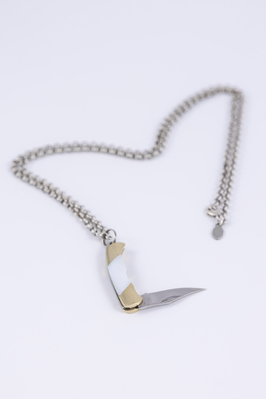 Folding knife necklace open to show sharp steel blade