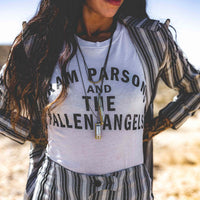 Woman wearing Sound as Ever harmonica necklace, knife necklace, and Gram Parsons and the Fallen Angels T-shirt