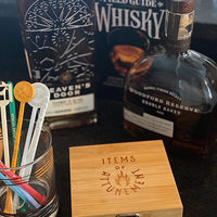 Whiskey stone set wooden box with brass clasp featuring text "Items of Attunement" and whiskey bottles in background