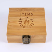 Whiskey stone set box closed to show antiqued brass metal clasp and text on top of wooden box reads "Items of Attunement"