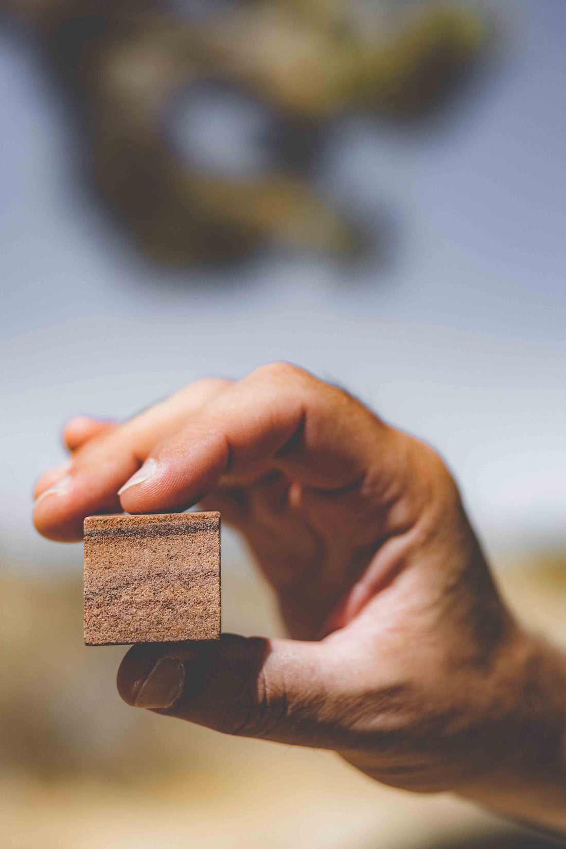 Whiskey stone made from desert quartz held up by a hand