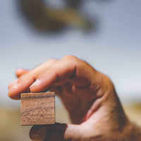 Whiskey stone made from desert quartz held up by a hand