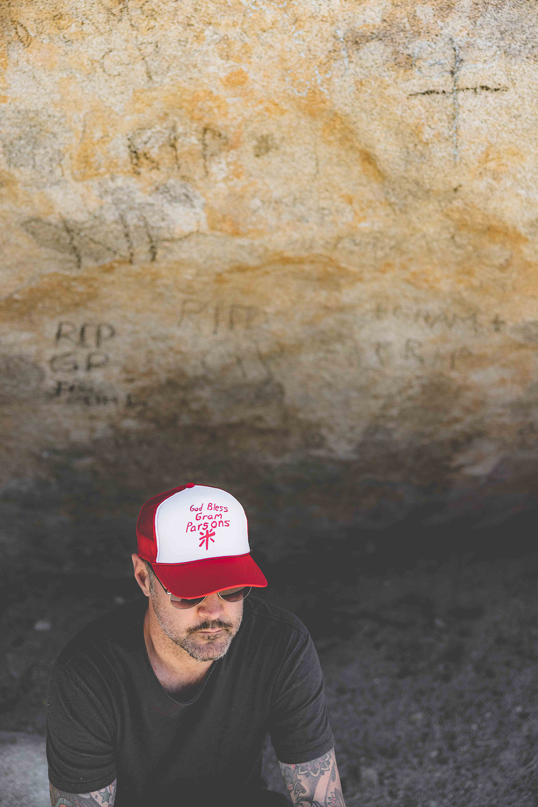 Map wearing white and red 70s trucker hat with text "God Bless Gram Parsons"