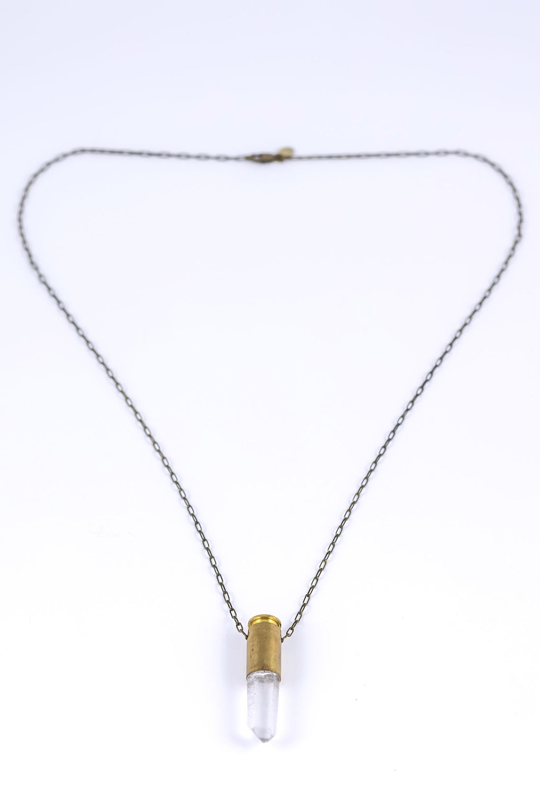 Bullet quartz necklace with brass bullet casing over clear quartz with an antique brass chain and clasp