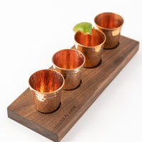 Set of four hammered copper shot glasses with walnut flight tray