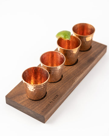 Set of four hammered copper shot glasses with walnut flight tray