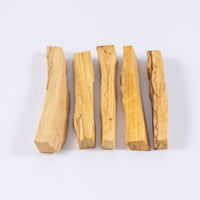 Ethically sourced palo santo sticks laid down in a row of similar but varying thicknesses