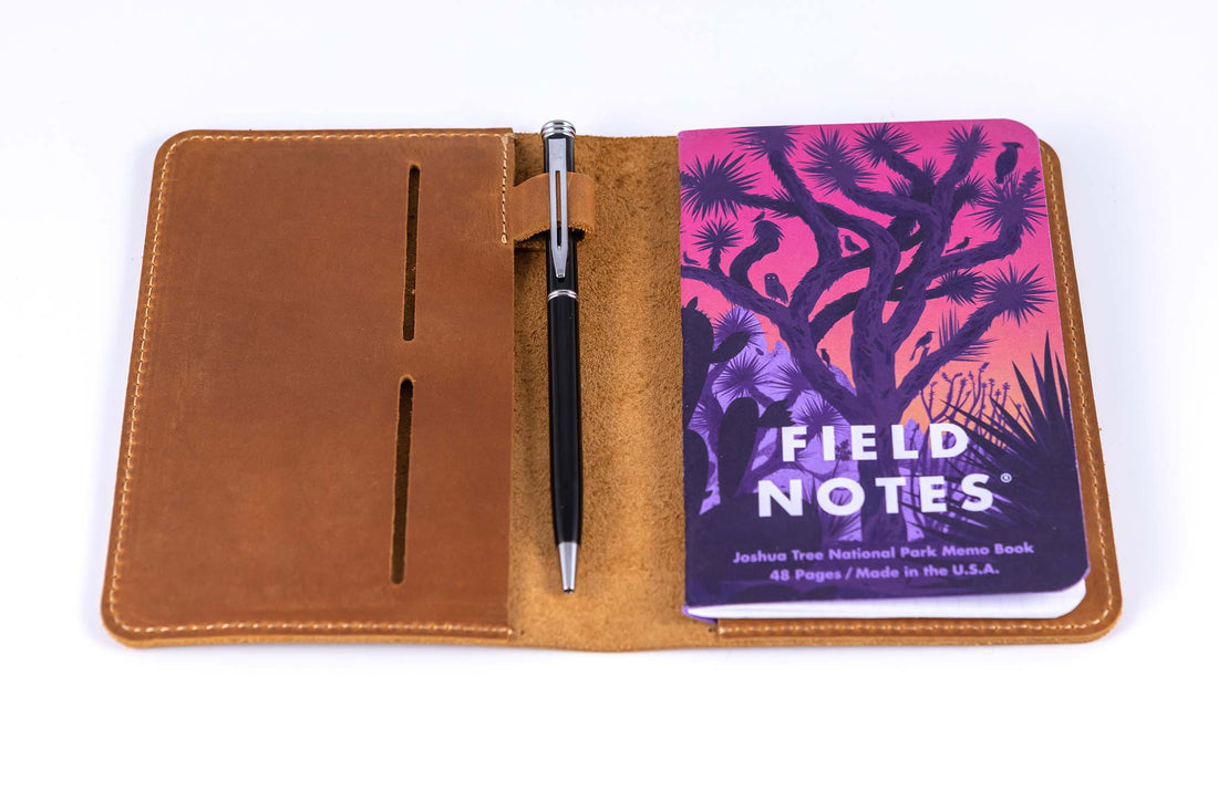 Close up view of inside of the leather field notes wallet with a pen and field notes memo book inside the pocket