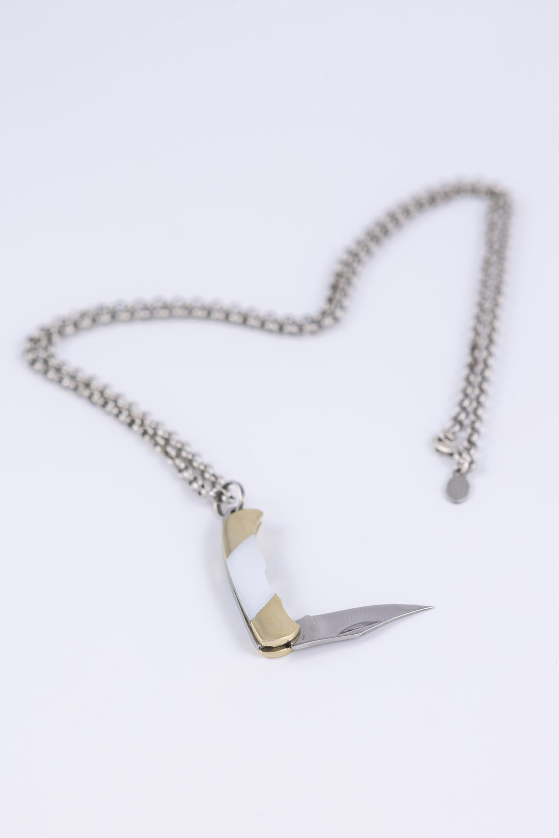 Folding knife necklace open to show sharp steel blade 