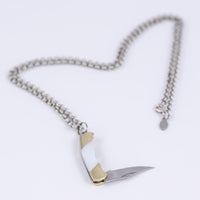 Folding knife necklace open to show sharp steel blade 