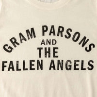 Close up of text on a vintage looking distressed off-white t-shirt with text "Gram Parsons and the Fallen Angels"