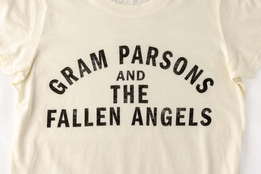 Close up of text on a vintage looking distressed off-white t-shirt with text "Gram Parsons and the Fallen Angels"