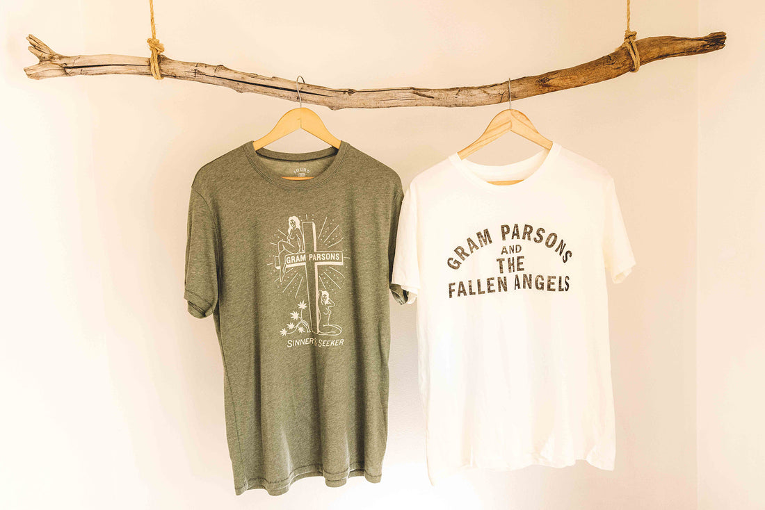 Gram Parsons and the Fallen Angels white distressed tshirt hanging next to Sound as Ever green Sinner Seeker t-shirt