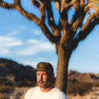 Man wearing Gram Parsons and the Fallen Angels white distressed t-shirt with Joshua tree in background