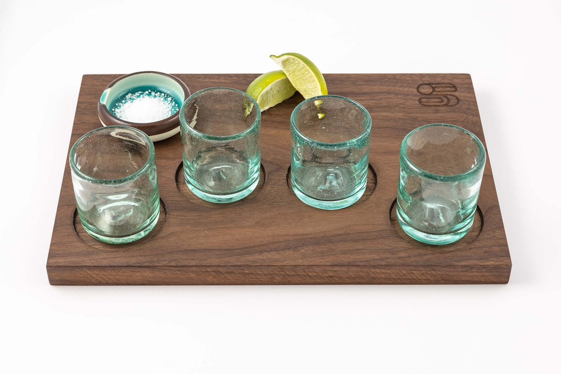 Landscape orientation view of Marfa Nights light blue Hand Blown Shot Glasses and dark wood flight tray with indentations for glasses