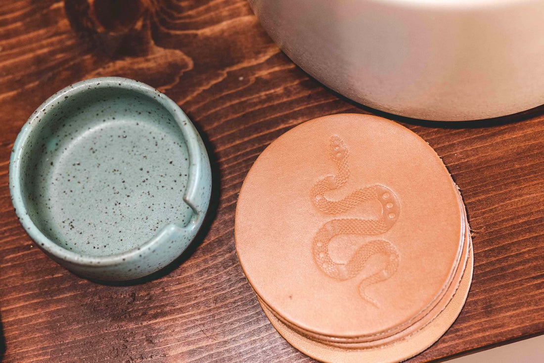 Leather coaster set embossed with Sidewinder design next to j ashtray