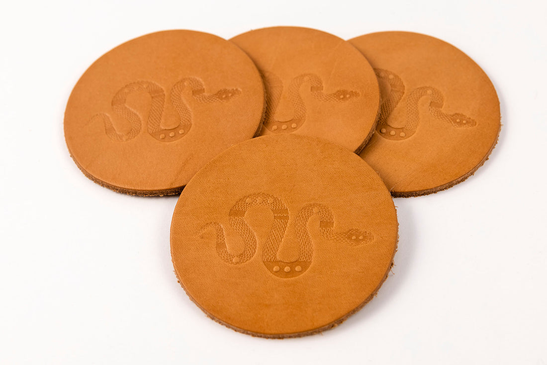 Set of four tan leather coasters displaying Sidewinder snake design