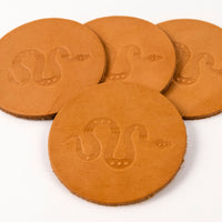 Set of four tan leather coasters displaying Sidewinder snake design