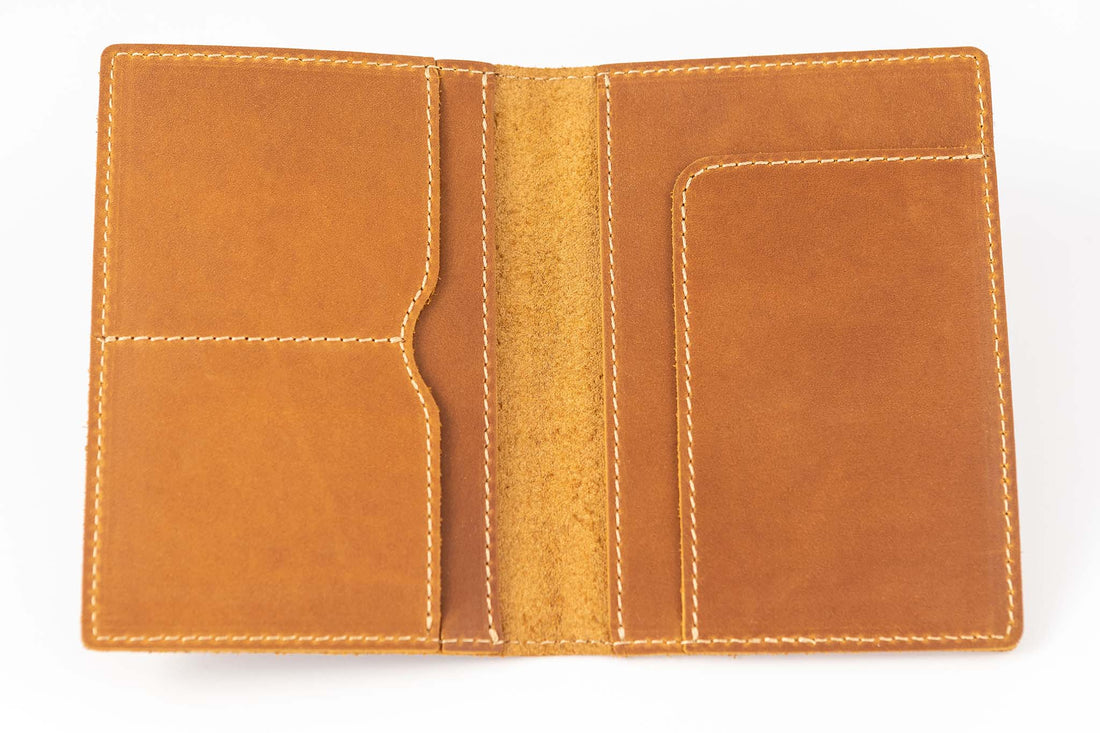 Brown handmade leather passport wallet fully open to display pockets and tan stitching