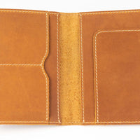 Brown handmade leather passport wallet fully open to display pockets and tan stitching