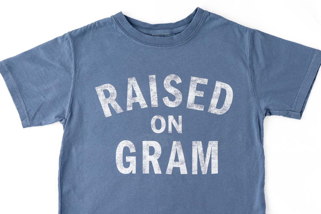 Blue graphic t-shirt for kids with white text "Raised on Gram"