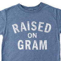 Blue graphic t-shirt for kids with white text "Raised on Gram"