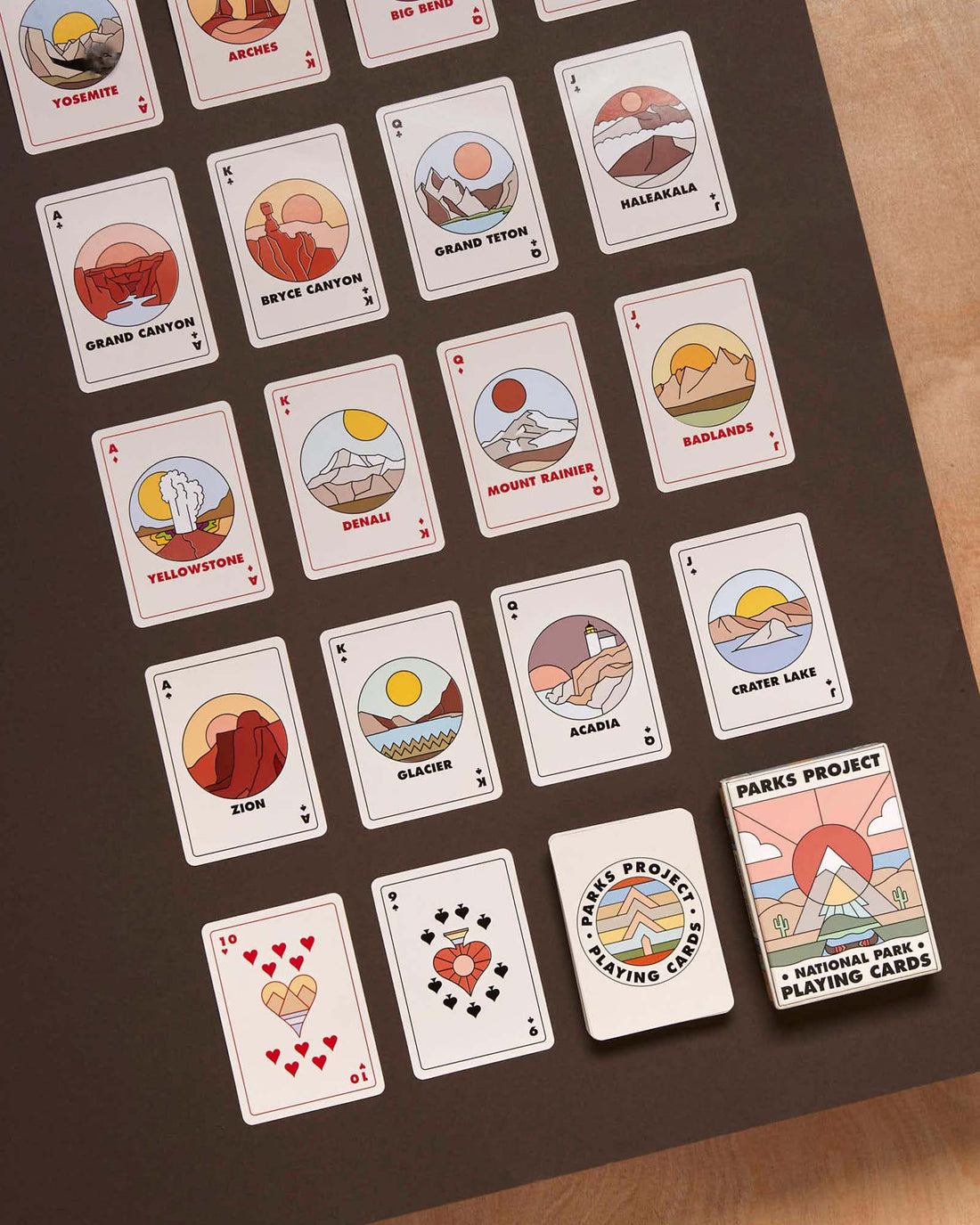 Over twenty National Parks playing cards laid out in a grid showcasing the minimalist colorful illustrations of the parks