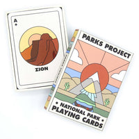 National Park playing cards showcasing the illustration for Zion national park next to the box with a design of mountains, cacti, and greenery