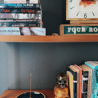 Natural incense stick and burner set on a wooden book shelf