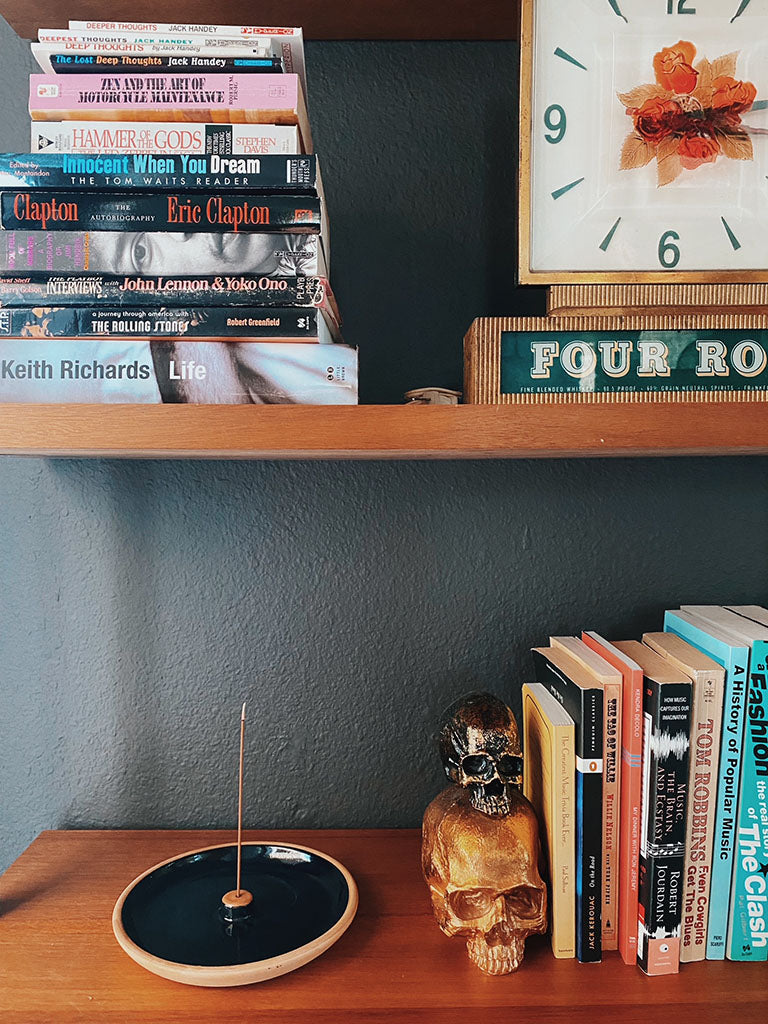 Natural incense stick and burner set on a wooden book shelf