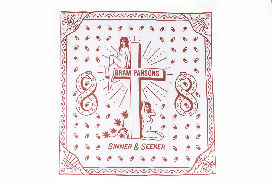 Sound As Ever Sinner & Seeker organic cotton bandana in the desert. The design has two women next to a cross, joshua trees, UFOs, and snakes in an infinity shape