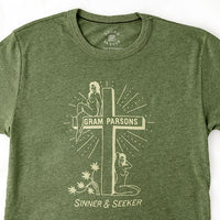 Light green vintage graphic t-shirt by Sound As Ever with two women, a cross, and text "Gram Parsons Sinner and Seeker"