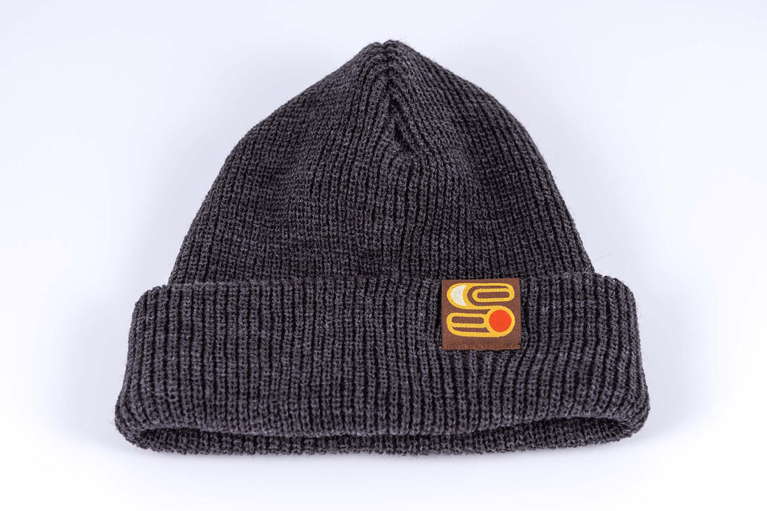 Close up view of gray Sound As Ever beanie with the Sound as Ever logo on a tag