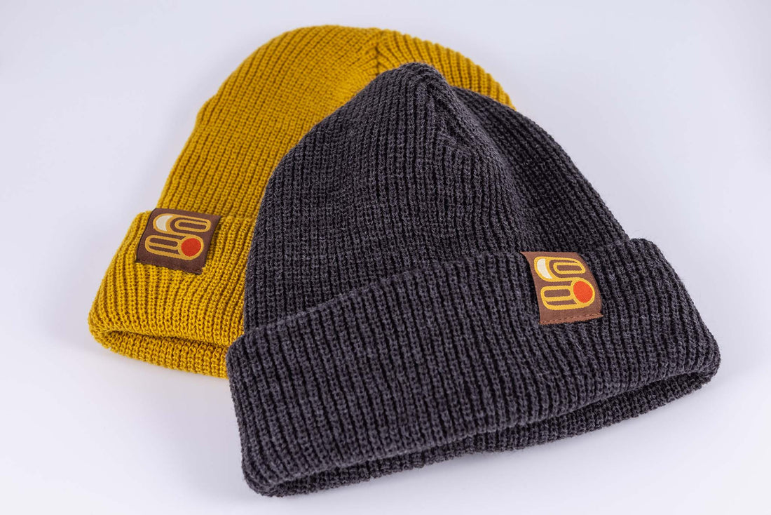 Close up view of Sound As Ever Beanie shown in yellow and gray colors with Sound as Ever Logo tag