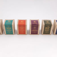 Soy wax candles in boxes showing six different options- cosmic wink, hickory wind, sunriser, avant gardener, desert elegy, and ode to dusk 