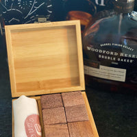 Whiskey stone set with six cubic stones made from light pink or tan desert striped quartz inside a wood box and with a bag featuring the Sound As Ever logo