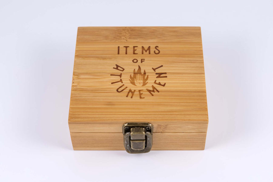 Whiskey stone set box closed to show antiqued brass metal clasp and text on top of wooden box reads "Items of Attunement"